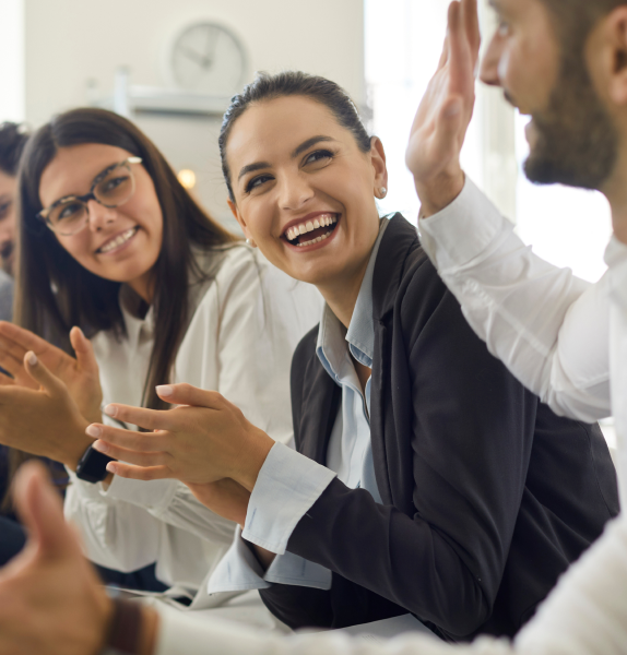 people laughing and applauding in a meeting