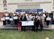 Families holding laptops distributed through the Leading Educational Attainment for Families Initiative, thanks to a generous donation from AT&T