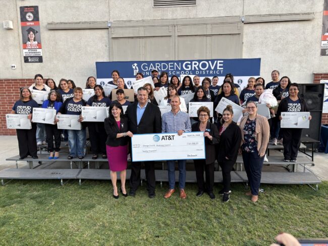 Families holding laptops distributed through the Leading Educational Attainment for Families Initiative, thanks to a generous donation from AT&T