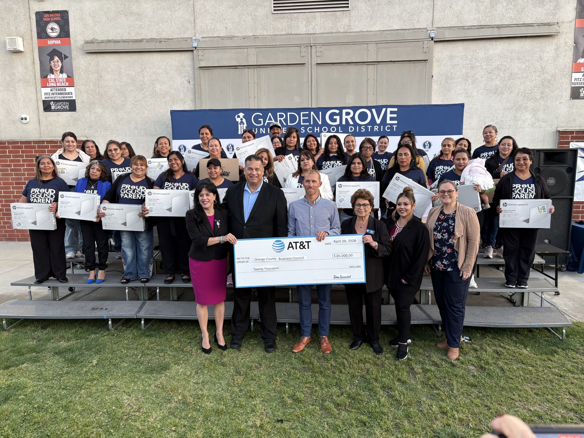 Families holding laptops distributed through the Leading Educational Attainment for Families Initiative, thanks to a generous donation from AT&T